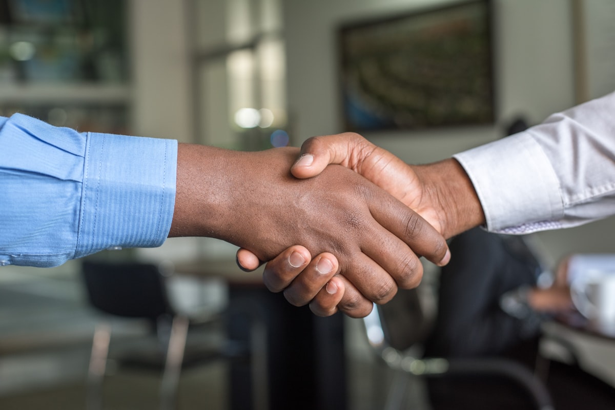 Dos personas estrechando manos en un ambiente profesional